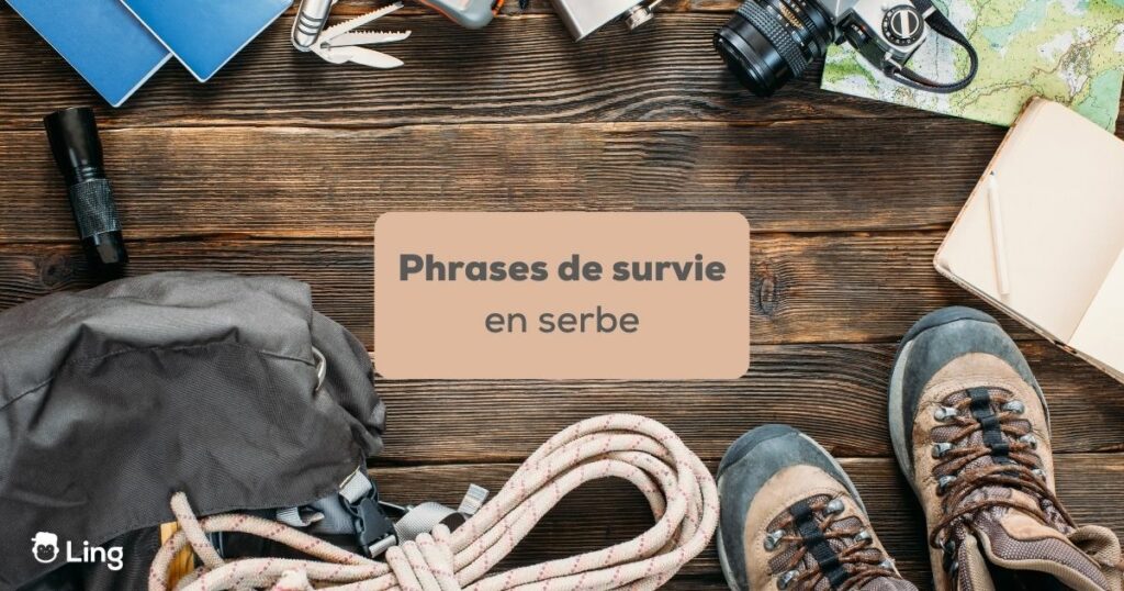 phrases de survie en serbe Kit de survie avec corde, chaussures de randonnées, carnet, sac, appareil photo et lampe de poche sur fond couleur bois