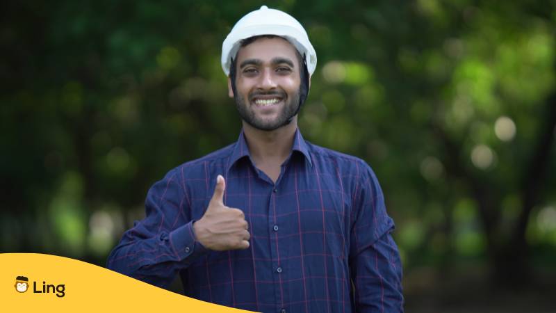 Junger indischer Ingenieur freut sich über ein Kennenlernen. Stelle deinen Beruf auf Malayalam vor – Stell dich auf Malayalam vor mit der Ling-App.