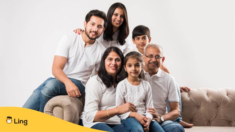 Indische sechsköpfige Familie sitzt auf dem Sofa. Wie lerne ich Malayalam schnell? Erfahre mehr mit der Ling-App!