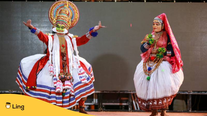 Zwei Menschen in traditioneller Kleidung bei einer traditionellen Aufführung. Lerne  
Malayalam Adjektive mit der Ling-App.