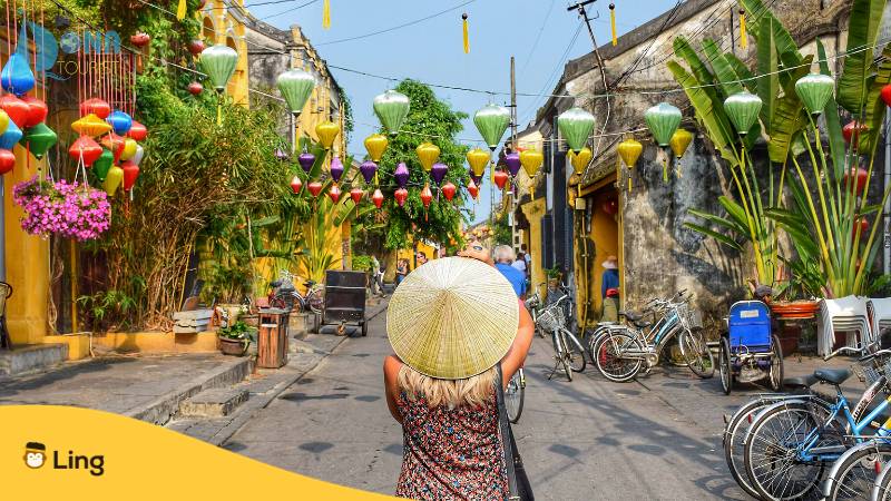 Frau trägt Strohhut in der Mitte der Straße in Vietnam. Erfahre, warum es kein Vietnamesisch bei Babbel gibt. Lerne Vietnamesisch mit der Ling-App.