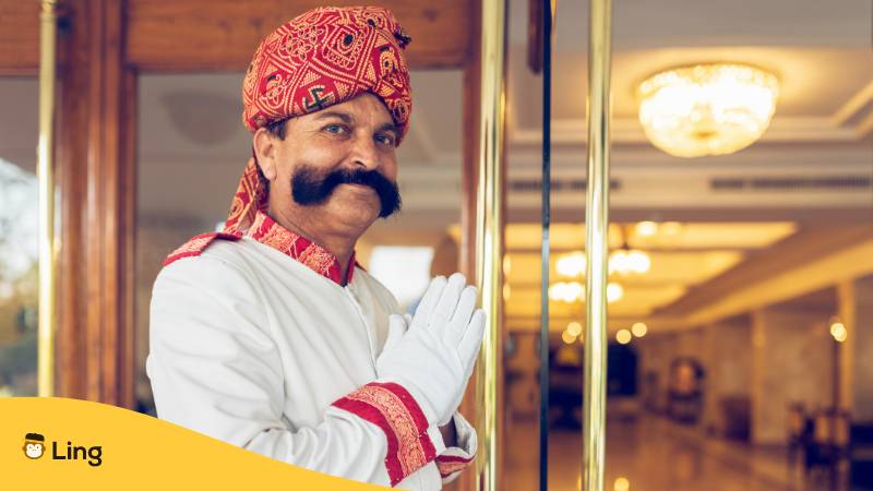 Indischer Concierge begrüßt Gast am Hoteleingang Indien. Lerne Begrüßungen auf Malayalam mit der Ling-App.