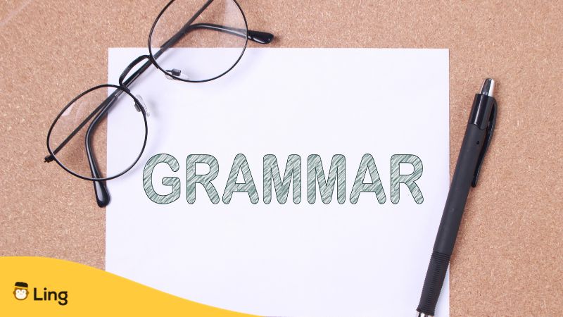 grammaire en thaï mot grammaire écrit sur feuille blanche avec lunettes et stylo noir à coté