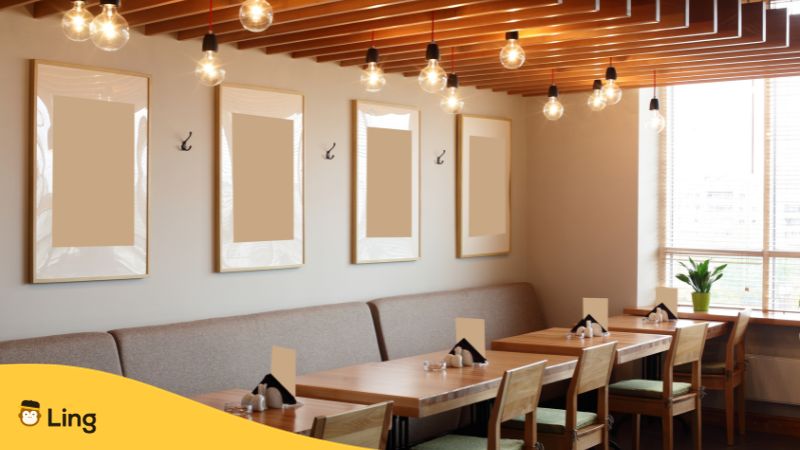 phrases courantes en lao
Salle de restaurant avec des tables; des chaises et des tableaux muraux