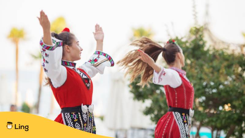 Frauen in traditioneller bulgarischer Volkstracht. Lerne 90 Länder und Nationalitäten auf Bulgarisch mit der Ling-App

