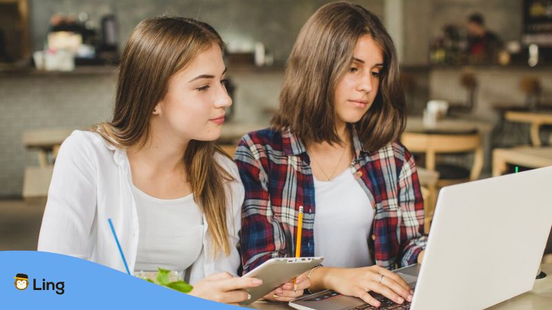 French online courses - A photo of two female language learners using a computer and a tablet.