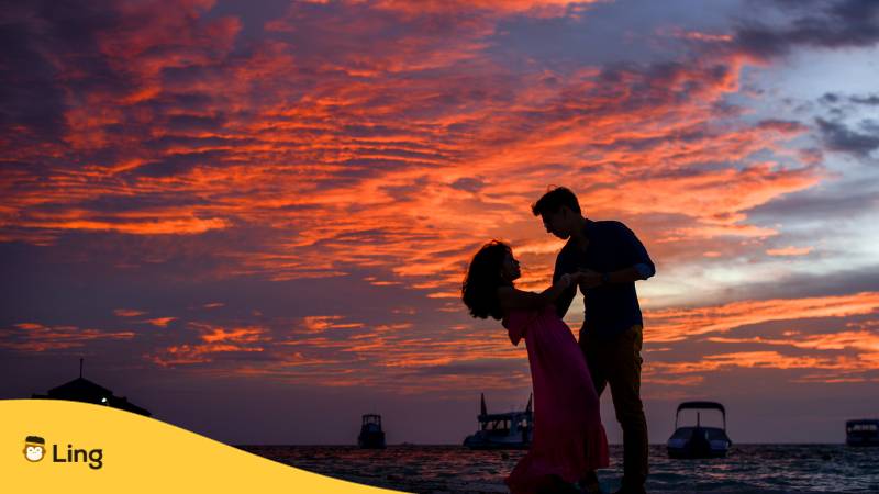 Mann und Frau romantisch am Strand bei Sonnenuntergang. Lerne mit der Ling-App die besten Wege, Ich vermisse dich auf Tagalog zu sagen.
