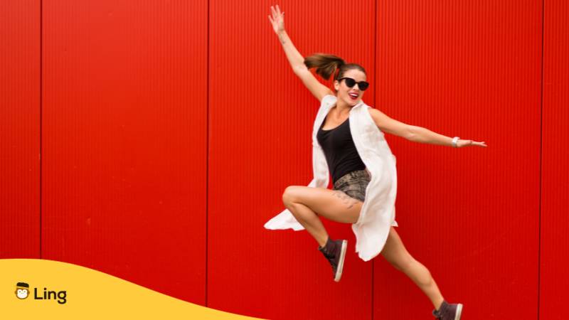 Aktive glückliche Frau springt vor rotem Hintergrund in die Luft. Lerne über 30 großartige Vokabeln, die du kennen solltest, um Gefühle auf Türkisch auszudrücken. Lerne Türkisch mit der Ling-App.
