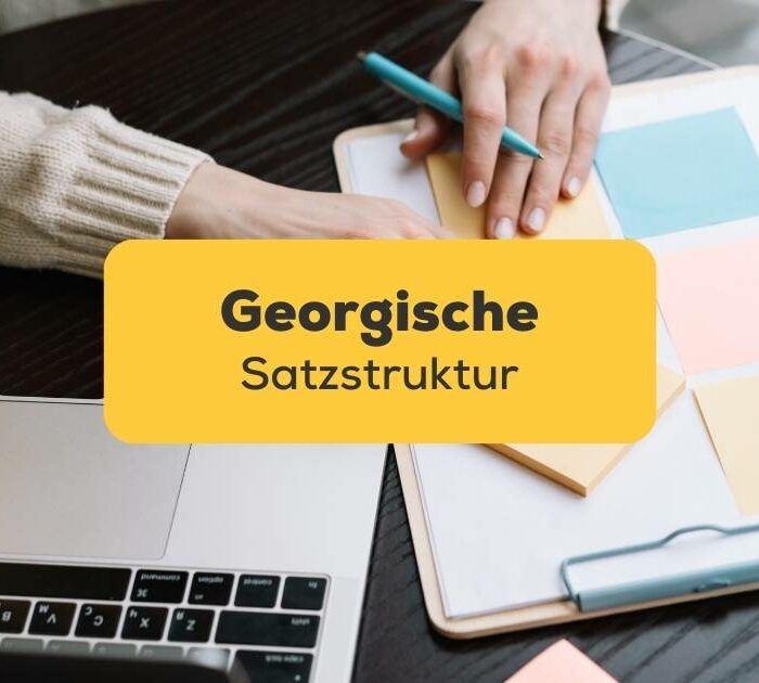 Georgisch lernende macht Notizen und arbeitet am Laptop. Lerne georgische Satzstruktur mit der Ling-App.