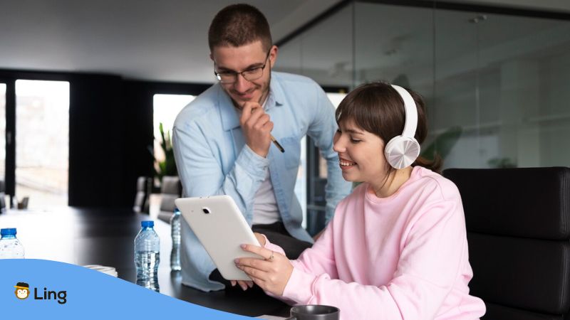 language apps for listening skills - A photo of a woman showing her tablet to a man.