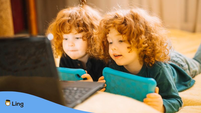 Language learning resources for kids - A photo of long-haired twins holding their tablets.