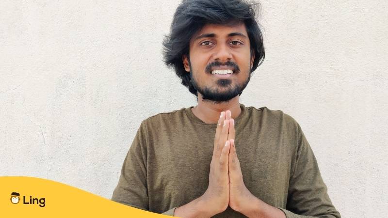 Südindischer Mann in vollen Ärmeln, der seine Handflächen mit einem Willkommensgruß zusammenhält. Vanakkam. Weißer Hintergrund. Lerne diese 7 einfachen Wege, um einen guten Morgen auf Tamil wünschen zu können! Lerne Tamil mit der Ling-App.