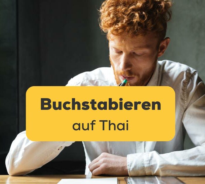 Junger westlicher Mann übt das Buchstabieren auf Thai.
