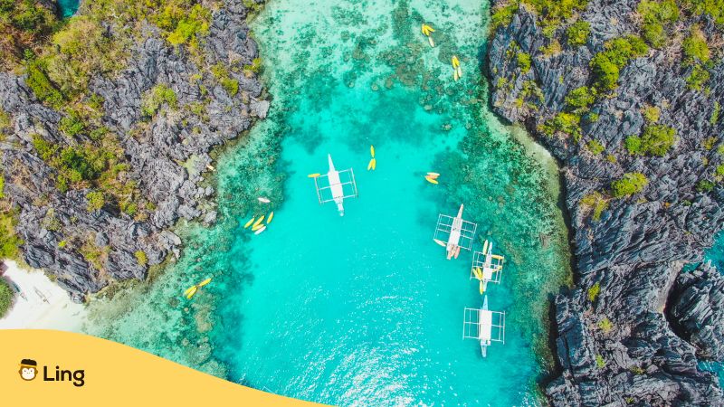 Traveling to El Nido Palawan Philippines - An aerial view of small lagoon with tourist boats.