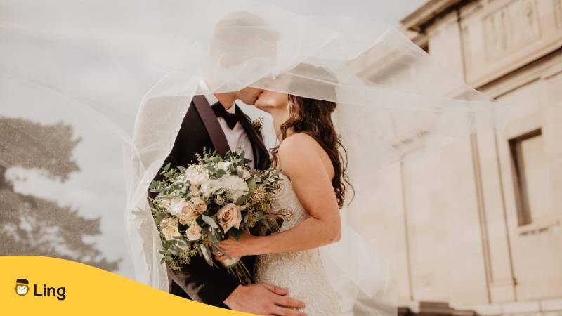 Frisch verheiratet, Paar küsst sich.
Lerne über 5 faszinierende Möglichkeiten, herzliche Glückwünsche auf Litauisch zu wünschen!