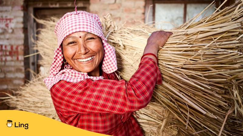 Nepali Frau lacht, während sie etwas körperlich arbeitet. Erfahre wie man sich auf Nepali vorstellen kann und entdecke 5 einfache Schritte mit der Ling-App!
