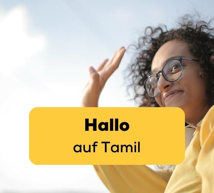 Frau hebt Hand um Hallo auf Tamil zu sagen, was sie dank der Ling-App gelernt hat