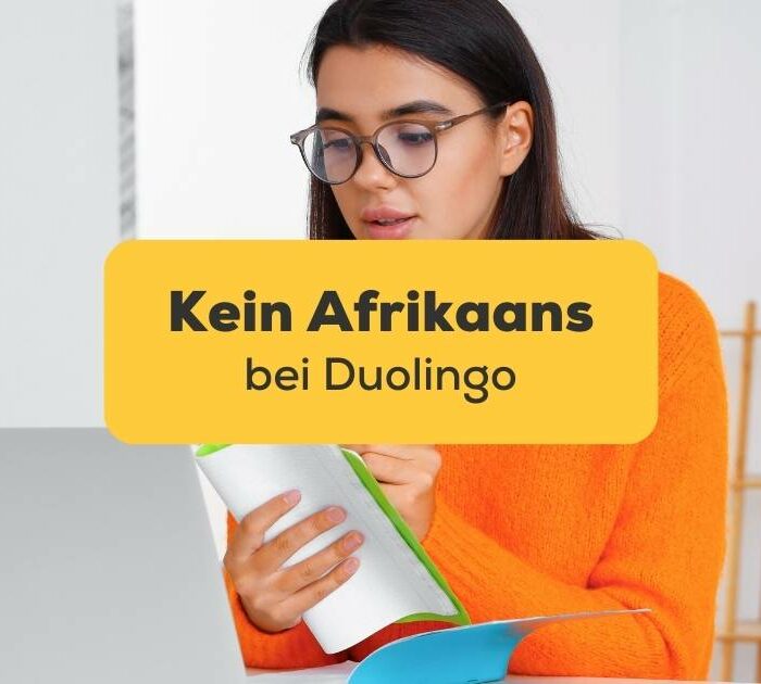 Junge Frau lernt die Afrikaans-Sprache online von zu Hause aus. Südafrika Flagge aus Seide.
