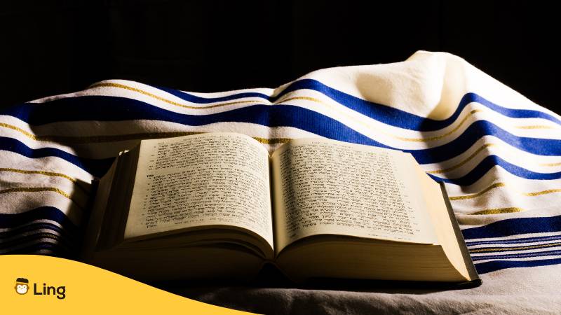 Hebräische Bibel und ein Tallit, ein jüdischer Gebetsschal.  Kein Hebräisch bei Babbel? Entdecke  die 2 besten Alternativen für 2024!
