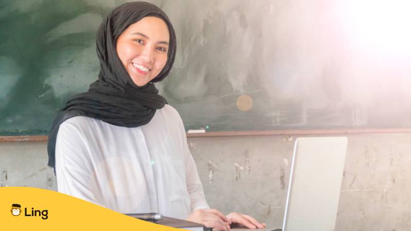 Malaiische Frau mit Hidschab bei der Arbeit mit Laptop. Erfahre, warum es kein Malaysisch bei Duolingo gibt? Probier stattdessen diese faszinierenden 2 Alternativen für 2024 aus.
