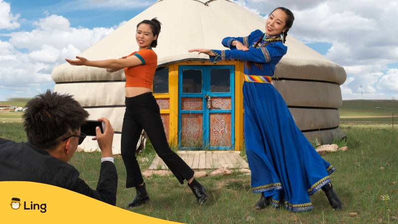 Touristenpaar lernt mongolischen Tanz. Erfahre, warum es kein Mongolisch bei Duolingo gibt? Entdecke die beste Alternative für das Jahr 2024!

