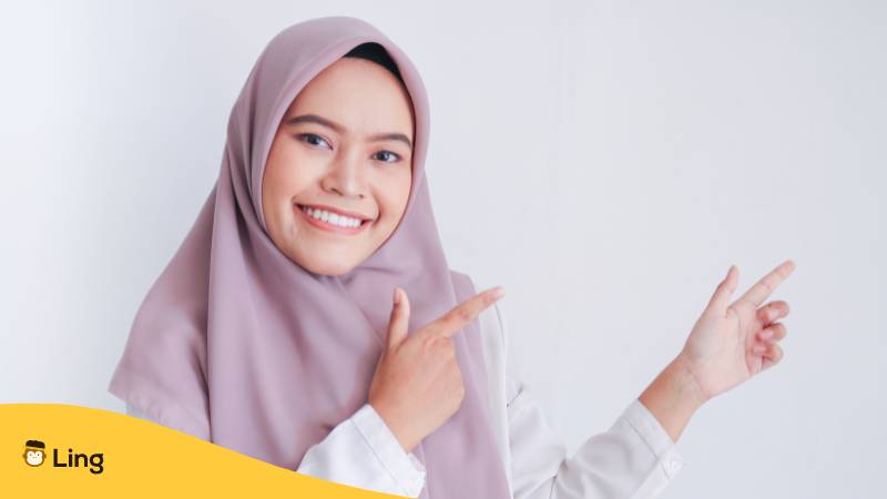Asiatischer muslimische Frau mit Kopftuch zeigt auf mit Finger. Erfahre, warum es kein Malaysisch bei Duolingo gibt? Probier stattdessen diese faszinierenden 2 Alternativen für 2024 aus.

