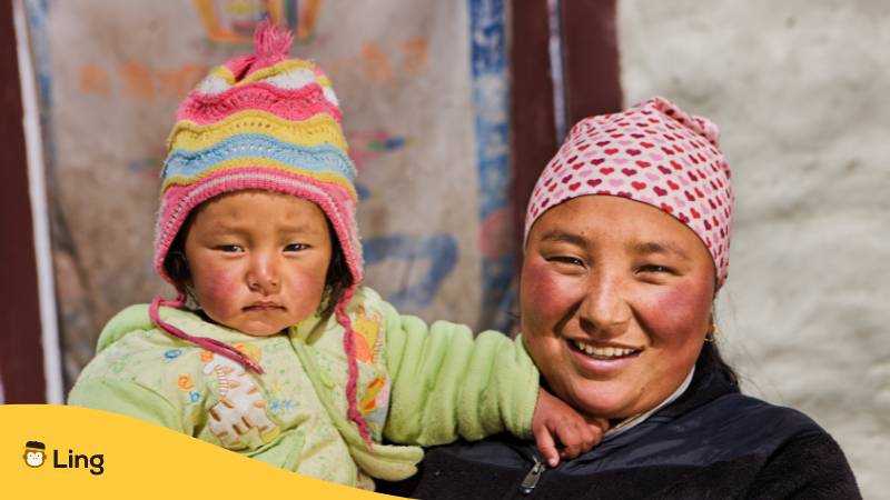 Nepalesische Frau mit ihrem Baby. Lerne 35 bedeutnede Nepali Vokabeln für die Familie mit der Genialen Ling-App!