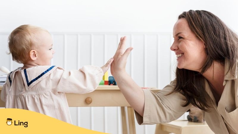 sign language apps - A photo of a mother and a baby doing high five.