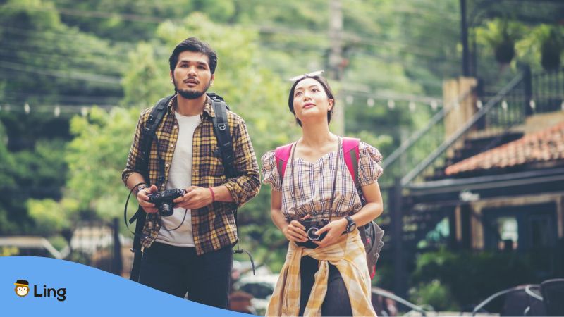 languages to learn for your Southeast Asia trip - A photo of two backpackers holding a camera.