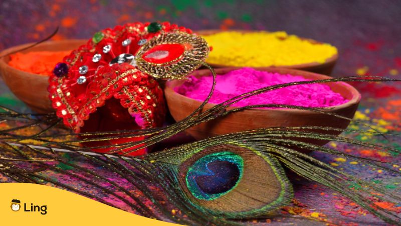 A peacock feather symbolising Krishna with Holi colors in the background