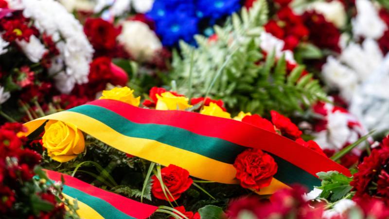 Blumenstrauß mit Schlaufe der litauischen Flagge dekoriert zum Unabhängigkeitstag. Entdecke die atemberaubende Geschichte der litauischen Sprache, mit unserem faszinierenden Leitfaden!
