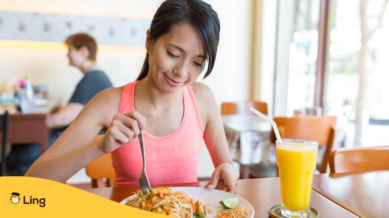 Thailänderin macht zu Mittags eine Pause, um etwas zu essen. Entdecke die 7+ besten Möglichkeiten, die Uhrzeit auf Thai sagen.  
