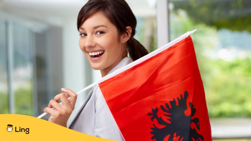 Hübsche junge Frau mit einer albanischen Flagge. Dein ultimativer Guide für albanische Grammatik!
