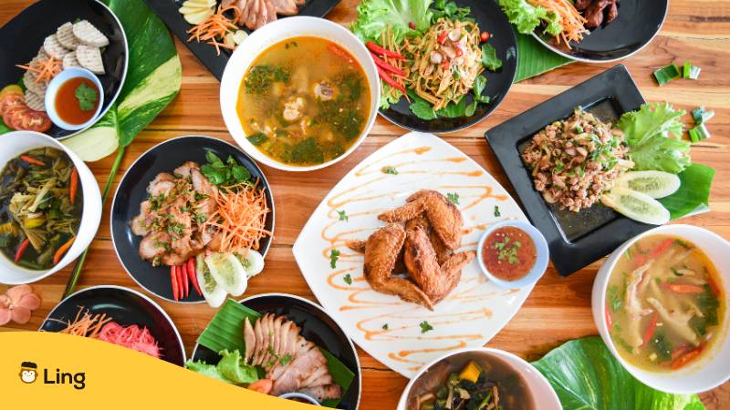 Leckeres Thai Essen auf dem Esstisch serviert. Lerne, wie man nicht scharf auf Thai bestellt, mit der Ling-App!