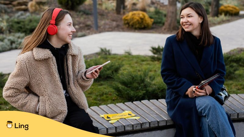 Best language learning software - A photo of two woman talking while sitting on a bench.