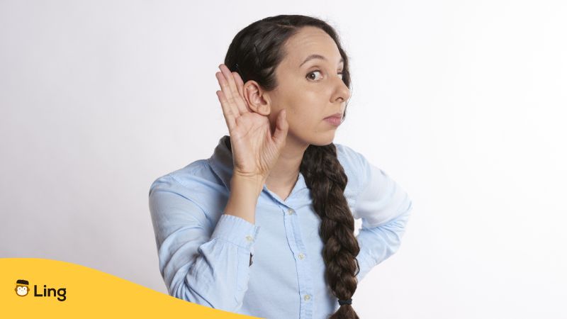Woman with a hand to her ear as if listening - Chinese pronunciation Ling app 