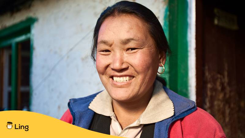 Frau aus Nepal lächelt herzlich. Lerne 10 einzigartige nepalesische Wörter mit Ling!
