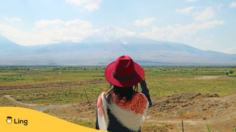 Frau mit Blick auf den wunderschönen Berg Ararat, das Gebirge, das in der Bibel als Ruheplatz der Arche Noah beschrieben wird, Armenien. Eine ultimative Anleitung für armenische Adjektive.