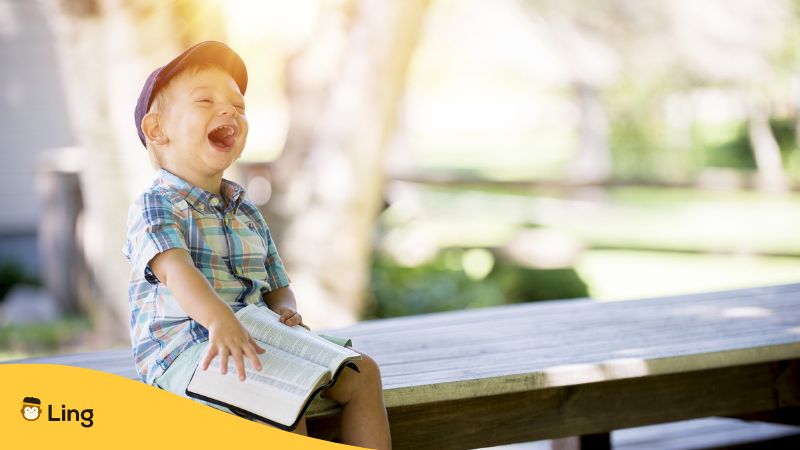 child laughing and reading slovenian idioms ling