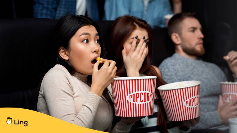 Gruseliger Filmabend. Ängstliches Publikum mit Popcorn schaut einen Horrorfilm im Kino. Entdecke 5 koreanische Horrorfilme, die dir eine Gänsehaut bescheren werden.
