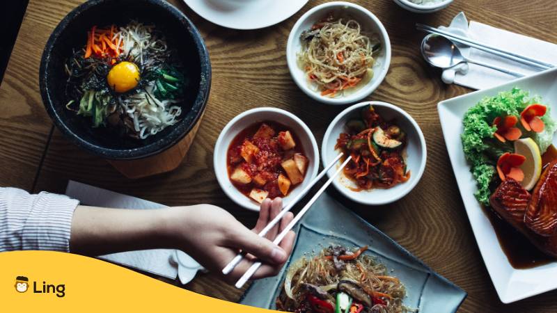 Frau isst von unterschiedlichen traditionellen koreanischen Essen. Entdecke die koreanische Kultur mit Ling!
