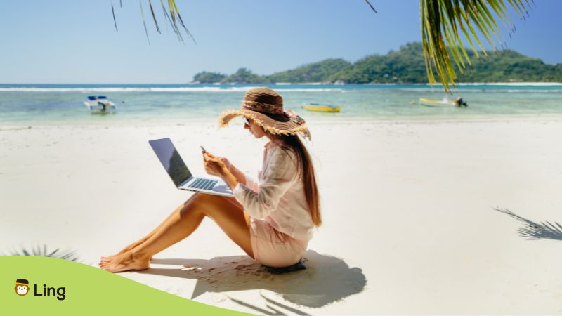 digital nomad Philippines - A photo of a female remote worker with her laptop at the beach.