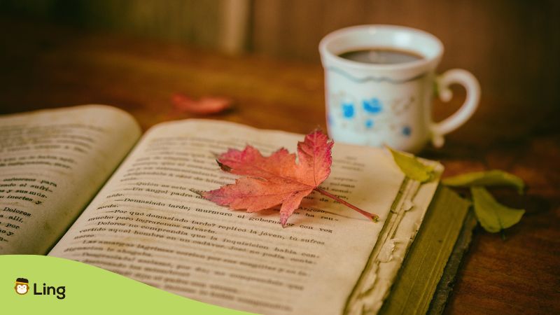 maple leaf on book and coffee cup