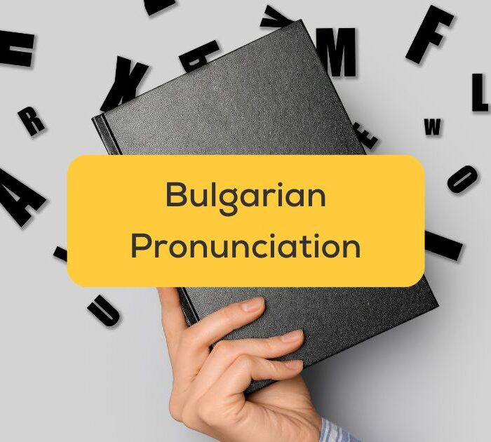 A hand holding a notebook with letters in the background - Bulgarian pronunciation