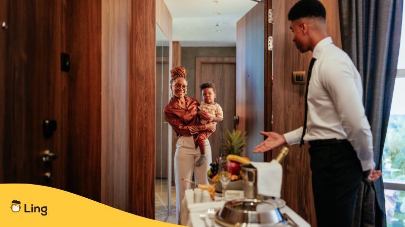 A Waiter Is Serving Food To A Woman With A Child In A Hotel Room