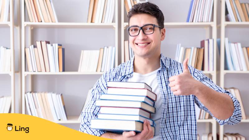 Mann Hält Bücher In Seinem Arm Und Macht Den Daumen