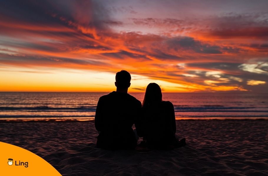 Silhouette Of A Couple Sitting At The Beach
