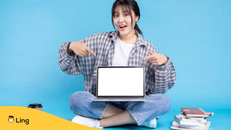 A Woman Pointing At A Computer To Symbolize Learning Croatian Online