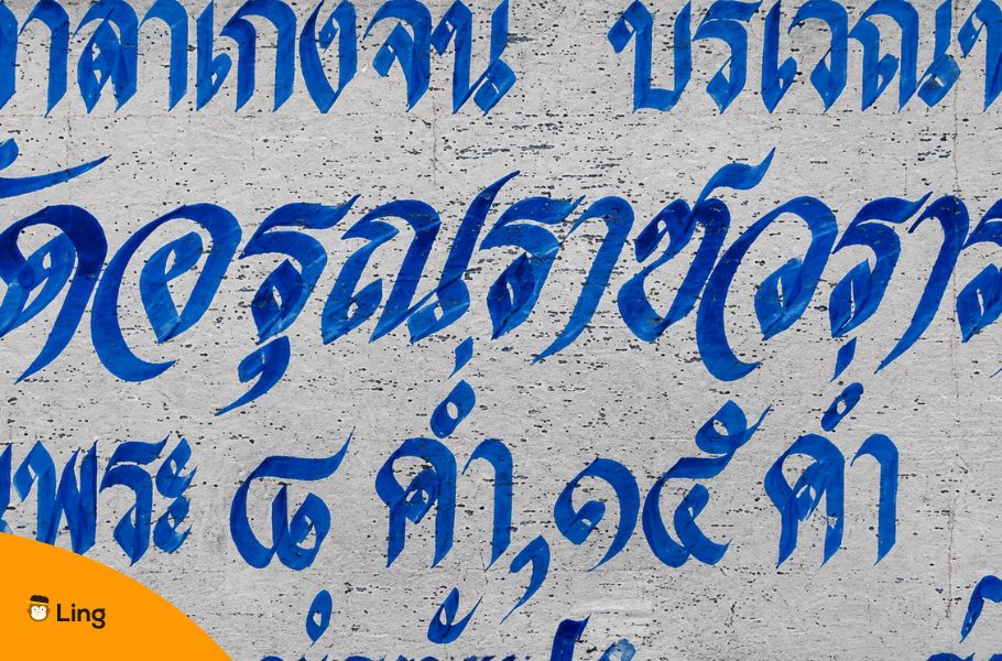 Blue Thai Script Painted On A Weathered Wall