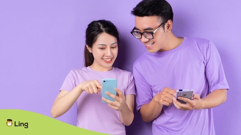 Dos Personas Usando Smartphones, Con Ropa Morada En Un Fondo Morado